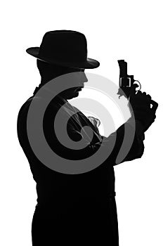 Silhouette of private detective with a gun in right hand. Agent stay side to camera and looks like mafioso Al Capone. Criminal