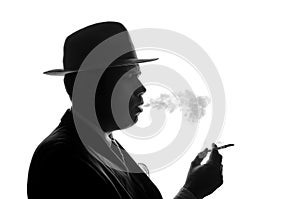 Silhouette of private detective lights cigarette. Agent looks like Al Capone stay side to camera. Police criminal scene in black
