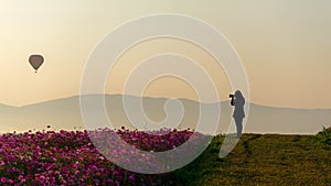 Silhouette professional woman photographer holding camera for take a photo balloon