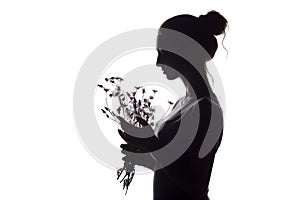 Silhouette profile of a beautiful girl with a bouquet of dried flowers on a white isolated background