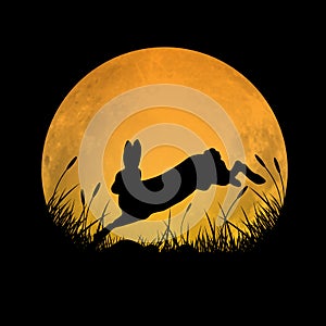 Silhouette of rabbit jumping over grass field with full moon background