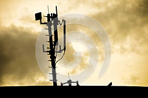 Silhouette of a radio telecommunication network antenna mounted on a metal pole