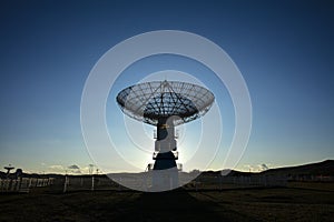 The silhouette of a radio telescope