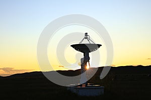 The silhouette of a radio telescope