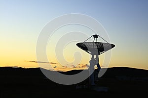 The silhouette of a radio telescope