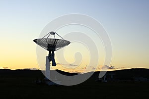 The silhouette of a radio telescope