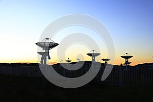 The silhouette of a radio telescope