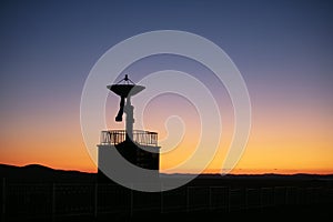 The silhouette of a radio telescope