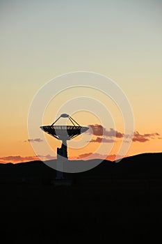 The silhouette of a radio telescope