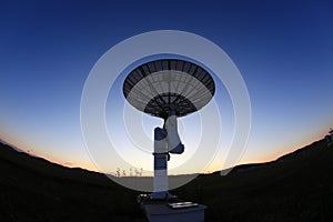 The silhouette of a radio telescope