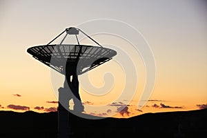 The silhouette of a radio telescope