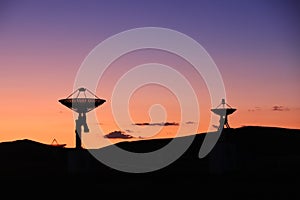 The silhouette of a radio telescope