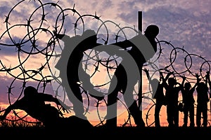 Silhouette of refugees and barbed wire