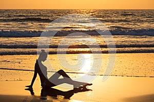 Silhouette of a relax girl on the beach at sunset. Woman on background of the ocean