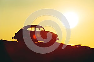 Silhouette of retro car on sunset
