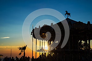 Silhouette of a retro carousel at sunset