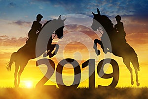 Silhouette the riders on the horse jumping into the New Year 2019.