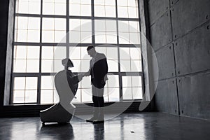 A man communicates with a robot, with cardboard box in hand. delivery concept. silhouette of the robot against the