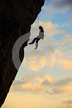 Silhouette of rock climber against cloudy sky