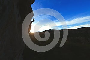 Silhouette of a rock climber against the sunset sky