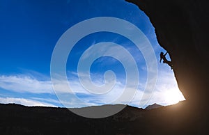 Silhouette of a rock climber against the sunset sky