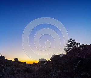 Silhouette of rocky area at sunset background. Colors of sunset sky. Coloured part of the sky after the sun disappearing