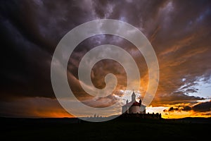 Silhouette of Romanian church with ray light after storm