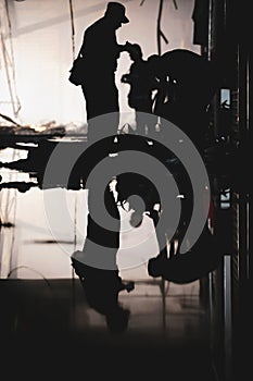 Silhouette of a Romanian fireman inspecting the site of a fire aftermath reflected in the water on the floor