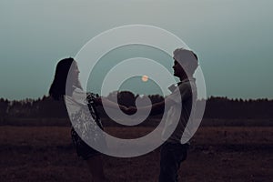 Silhouette of a romantic couple enjoying beautiful sunset on outdoors