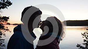 Silhouette of romantic talking couple of man and woman against sunset. Romance and active date happy people