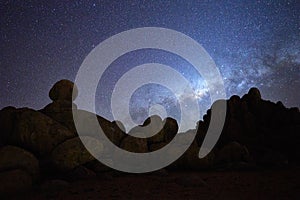 Silhouette of rounded rocky structures against milky way and the stars of african sky. Night sky photo. Twyfelfontein, Madisa,