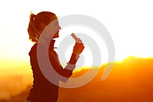 Silhouette of runner eating energy bar after running