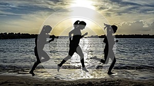 Silhouette of runner woman, running on the beach at sunset