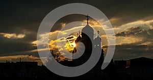Silhouette of a Russian Orthodox Church in Barnaul, dramatic sunset with rays of light