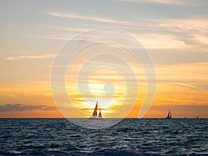 Silhouette of sail boat crosses over sun setting in Puerto Vallarta Mexico over Banderas Bay from Hotel Zone photo