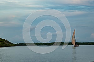 Silhouette of a sailboat on sea against sky during sunset in Shela Beach, Lamu Island, Kenya