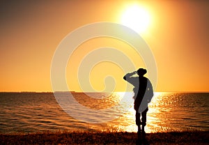 Silhouette of saluting on shore commando solder