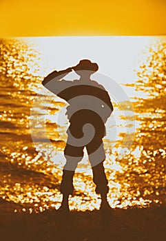 Silhouette of saluting on shore commando solder