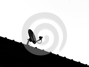 silhouette of satellite antenna dish and TV antennas mounted isolate on roof house with copy space