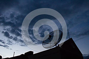 Silhouette satellite dish on house