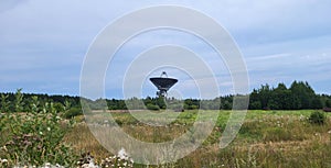 The silhouette of a satellite dish or radio antenna. Space observatory or air defense radar.