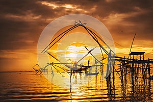 Silhouette scenery of sunrise at pakpra phatthalung with thai traditional fishing trap