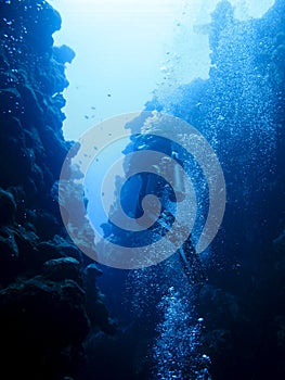 Silhouette of a scuba diver swimming out of the canyon divesite in Dahab, Egypt