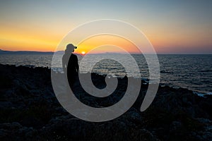 Silhouette Serenity: A Young Soul Embraces Rethymno\'s Sunset Magic