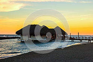 Silhouette shot of a bamboo hut on the sea during sunset