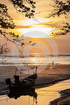 Silhouette shot of fishing boat on the beach during sunset