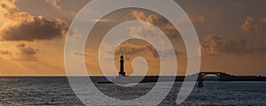 Silhouette shot of harbor entrance with lighthouse and bridge at sunrise time located in Montaza Park, Alexandria, Egypt