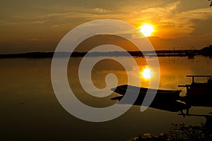 Silhouette shot, Sunset with boat over lake or pond or swamp o