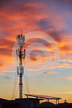 Silhouette signal antenna tower at sunset sky