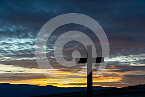 Silhouette of a simple wood catholic cross at sunset